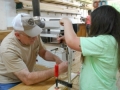 BRWC member Roy Smith assist the kids with using a brace and bit to drill holes